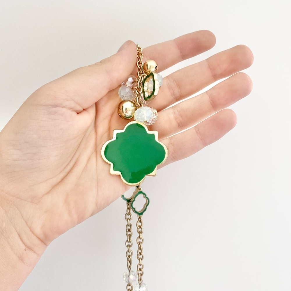 Green necklace on gold chain.